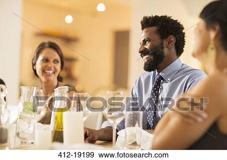Friends laughing at dinner party View Large Photo Image Stock Photo - Friends laughing at dinner party. Fotosearch