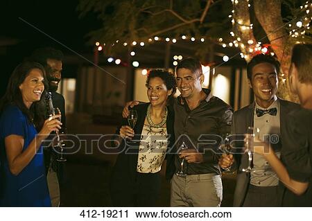 Friends laughing together at party View Large Photo Image Stock Image - Friends laughing together at party. Fotosearch