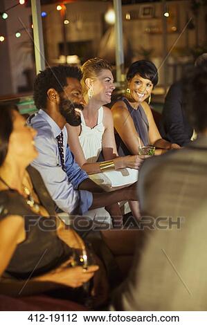 Stock Image - Friends relaxing at party. Fotosearch