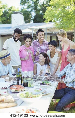 Friends relaxing together at table outdoors View Large Photo Image Stock Image - Friends relaxing together at table outdoors. Fotosearch