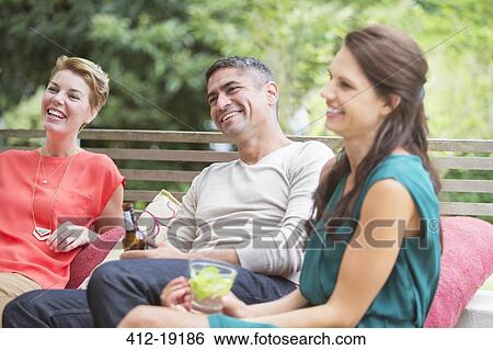 Stock Photograph - Friends relaxing together outdoors. Fotosearch