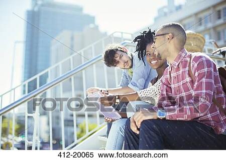 Stock Photography - Friends sitting on city steps. Fotosearch