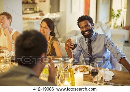 Friends talking at dinner party View Large Photo Image Stock Photograph - Friends talking at dinner party. Fotosearch