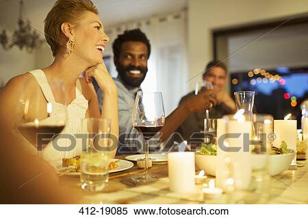Stock Photography - Friends talking at dinner party. Fotosearch