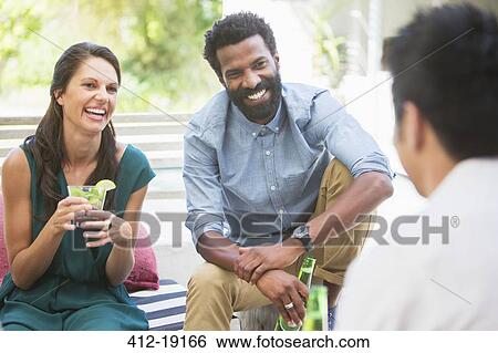Friends talking at party View Large Photo Image Stock Photograph - Friends talking at party. Fotosearch
