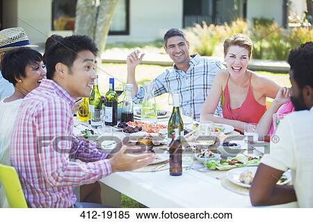 Friends talking at table outdoors View Large Photo Image Stock Photography - Friends talking at table outdoors. Fotosearch