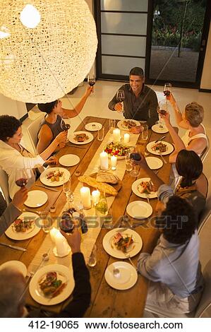 Friends toasting each other at dinner party View Large Photo Image Stock Photography - Friends toasting each other at dinner party. Fotosearch