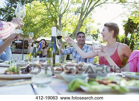 Friends toasting each other at party View Large Photo Image Stock Image - Friends toasting each other at party. Fotosearch