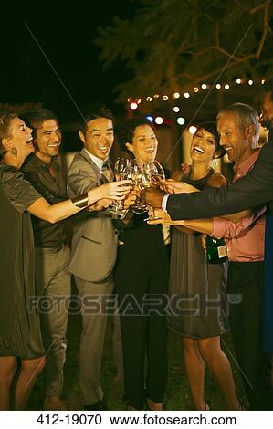 Stock Image - Friends toasting each other at party. Fotosearch