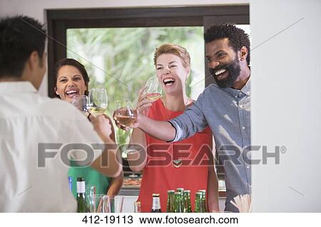 Friends toasting each other at party View Large Photo Image Stock Image - Friends toasting each other at party. Fotosearch
