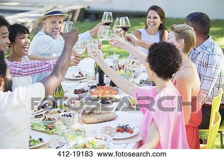Stock Image - Friends toasting each other at party. Fotosearch