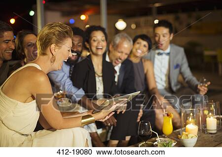 Friends using digital tablet at party View Large Photo Image Stock Image - Friends using digital tablet at party. Fotosearch