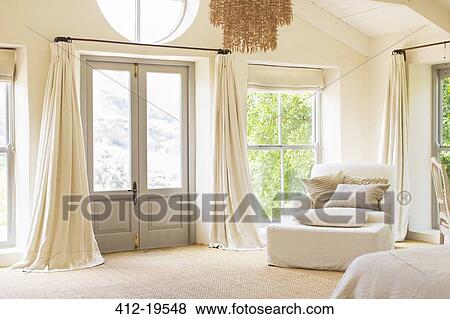 Stock Photo - Front door and armchair in rustic house. Fotosearch
