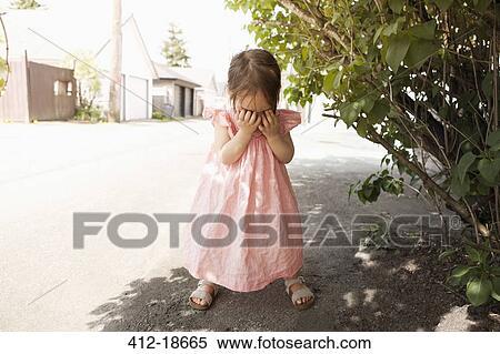 Stock Photography - Girl covering her face outdoors. Fotosearch