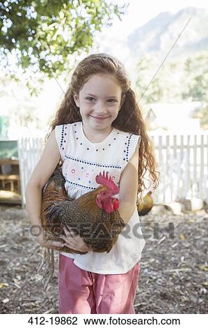 Girl holding chicken at petting zoo View Large Photo Image Stock Image - Girl holding chicken at petting zoo. Fotosearch