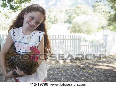 Girl holding chicken at petting zoo View Large Photo Image Stock Photograph - Girl holding chicken at petting zoo. Fotosearch