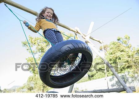Girl playing on tire swing View Large Photo Image Stock Photography - Girl playing on tire swing. Fotosearch