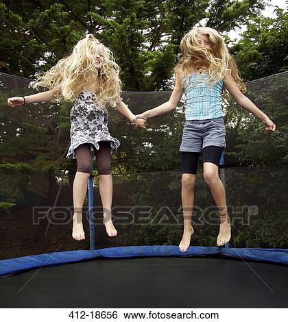 Girls jumping on trampoline outdoors View Large Photo Image Stock Photograph - Girls jumping on trampoline outdoors. Fotosearch
