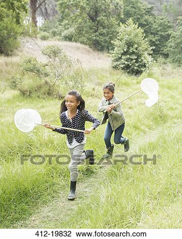 Girls using butterfly nets in field View Large Photo Image Stock Image - Girls using butterfly nets in field. Fotosearch