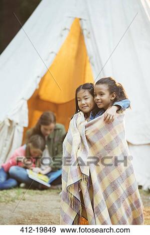 Girls wrapped in blanket at campsite View Large Photo Image Stock Photo - Girls wrapped in blanket at campsite. Fotosearch