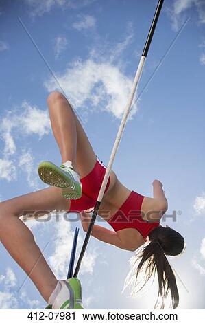 Stock Image - High jumper clearing bar. Fotosearch
