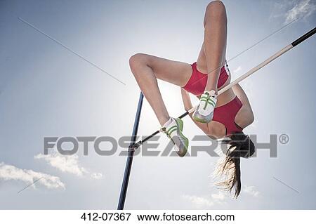 Stock Photo - High jumper clearing bar. Fotosearch
