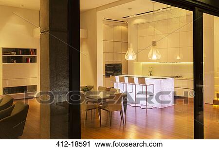 Stock Image - Kitchen and dining area in modern house. Fotosearch