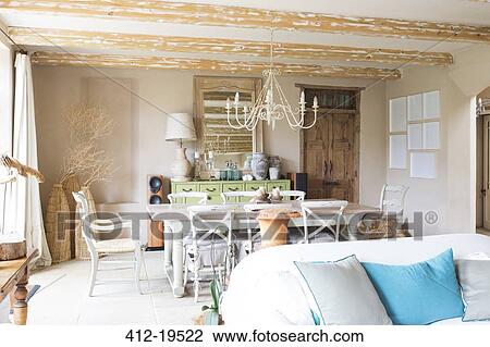 Stock Image - Living and dining area in rustic house. Fotosearch