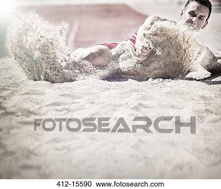 Stock Image - Long jumper landing in sand. Fotosearch