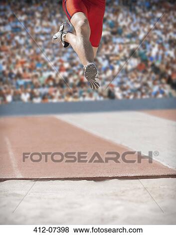 Stock Photo - Long jumper over sand pit. Fotosearch