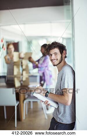 Man carrying book in office View Large Photo Image Stock Photograph - Man carrying book in office. Fotosearch