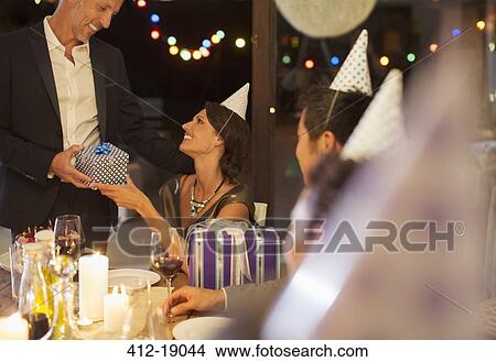 Man giving present at birthday party View Large Photo Image Picture - Man giving present at birthday party. Fotosearch