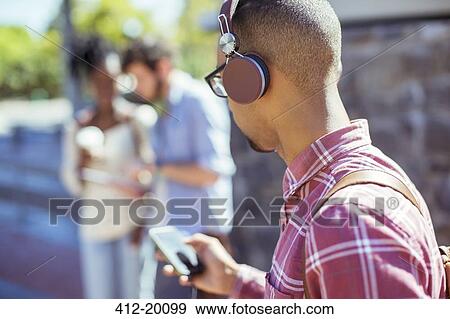Man listening to mp3 player outdoors View Large Photo Image Stock Photo - Man listening to mp3 player outdoors. Fotosearch