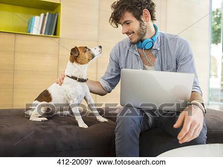 Stock Photo - Man petting dog in office. Fotosearch