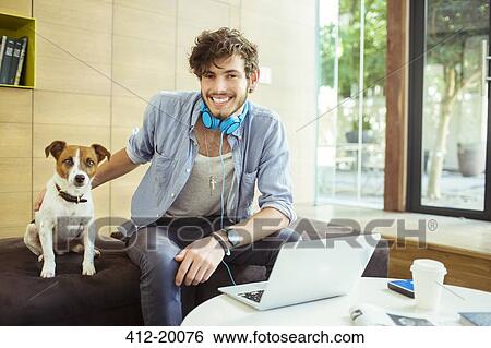 Man petting dog in office View Large Photo Image Stock Photograph - Man petting dog in office. Fotosearch