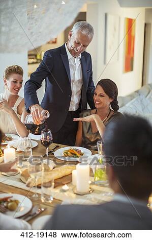 Stock Photo - Man serving wine at dinner party. Fotosearch