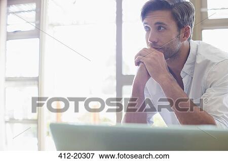 Stock Photo - Man sitting at laptop. Fotosearch