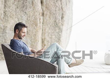 Man sitting in modern armchair View Large Photo Image Stock Photo - Man sitting in modern armchair. Fotosearch