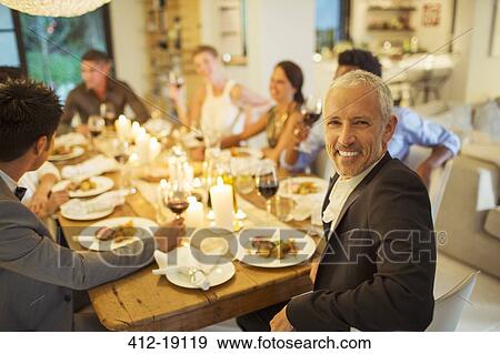 Man smiling at dinner party View Large Photo Image Stock Photo - Man smiling at dinner party. Fotosearch