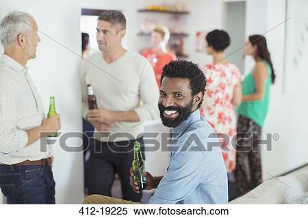 Stock Photography - Man smiling at party. Fotosearch