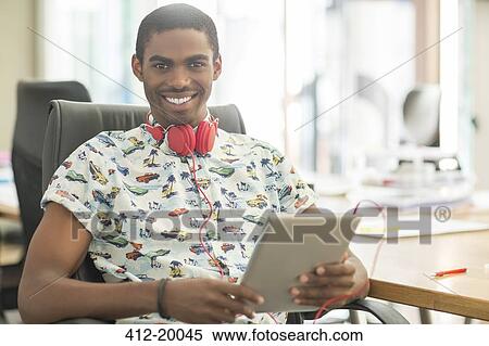 Stock Photography - Man using digital tablet in office. Fotosearch