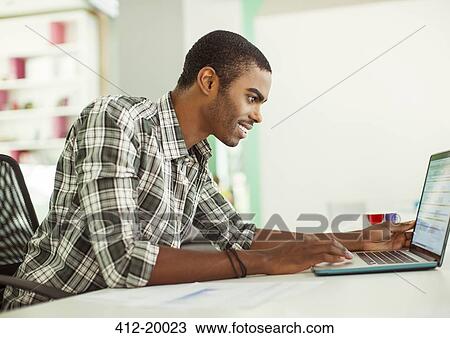 Man working on laptop in office View Large Photo Image Stock Image - Man working on laptop in office. Fotosearch