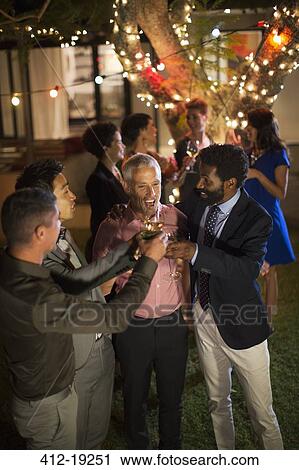 Men toasting each other at party View Large Photo Image Stock Image - Men toasting each other at party. Fotosearch