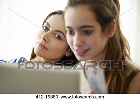 Mother watching daughter use laptop View Large Photo Image Stock Image - Mother watching daughter use laptop. Fotosearch