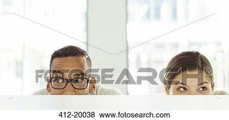 People peeking over cubicle in office View Large Photo Image Stock Photo - People peeking over cubicle in office. Fotosearch