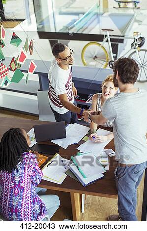 Stock Image - People shaking hands in office. Fotosearch