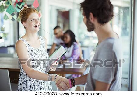 Stock Photo - People shaking hands in office. Fotosearch