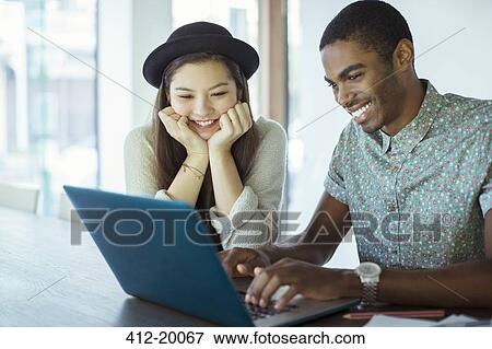 Stock Photo - People working together on laptop in office. Fotosearch