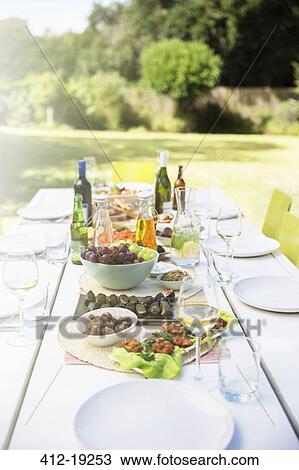 Plates of food on table outdoors View Large Photo Image Stock Image - Plates of food on table outdoors. Fotosearch