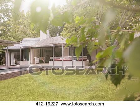Pool and lawn in backyard of modern house View Large Photo Image Stock Photo - Pool and lawn in backyard of modern house. Fotosearch